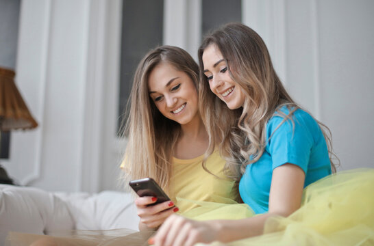 two young women use a smartphone