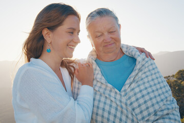 Portrait of two women young and elderly. Young woman hugs senior caucasian woman outdoor at sunrise. Models look into the camera - 584777429