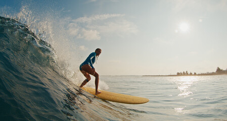 Fototapeta na wymiar Slim woman surfer rides the wave. Woman surfs the ocean wave in the Maldives on yellow longboard