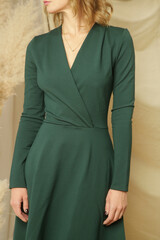 Serie of studio photos of young female model in green elegant midi dress 