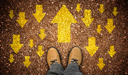 Yellow leather shoes and colorful chalky arrows in opposite directions - motivation concept
