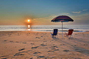 Beach umbrella and chairs on the beach at Sunrise