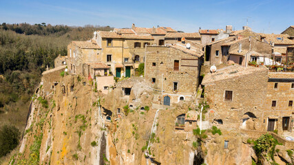 Obraz premium Aerial view of the houses of Calcata, a small town near Viterbo, Italy. All buildings in the historical centre are built in stone and tuff and have red tiled roofs. Italian village.