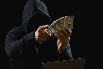 Hacker spy man hands wearing a black shirt, sitting on a chair and a table, is a thief, holding...