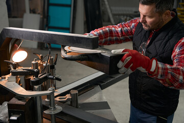 Adult male working with metal parts constructions