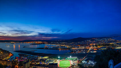 Fototapeta premium Sunset view over Gibraltar - a British Overseas Territory, and Spanish town of La Líinea de la Concepcion on Bay of Gibraltar