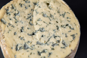 close up on a Piece of blue Fourme d' Ambert French cheese isolated on a black background