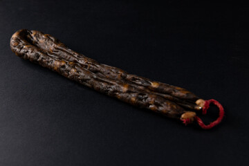 Figatellu liver sausage isolated on a black background