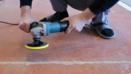 emery yellow round nozzle on a grinder in the hands of a person in the process of grinding an old...