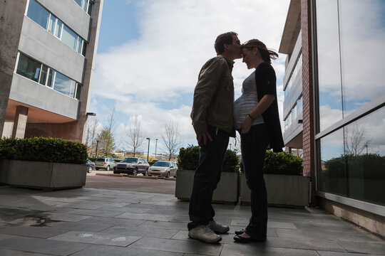 Man kissing pregnant womans forehead  - happy expecting parents