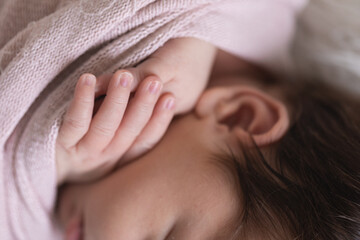 Obraz na płótnie Canvas close up of newborn hand and fingernails, ear and fluffy hair