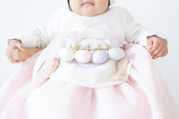close up of one year old baby girl wearing a pastel colored white hanbok dress outfit - Powered by Adobe