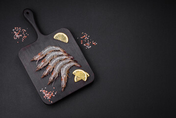 Tiger prawn or langoustine raw with spices and salt on a wooden cutting board