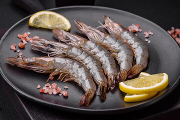 Tiger prawn or langoustine raw with spices and salt on a wooden cutting board