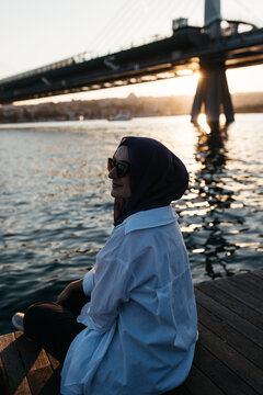 Woman with headscarf enjoying the view of an open sea