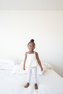 Girl on bed with bun camera aware