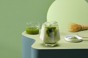 Iced Green matcha tea mixed with ice cube and milk in latte glass