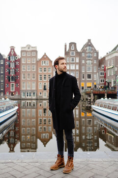 Gentleman posing on quay near river in old city