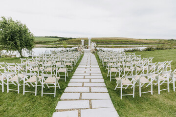 Outside wedding ceremony white chairs event nature