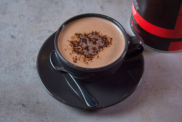 Hot Chocolate serving in coffee cup with spoon and beans side view on grey background