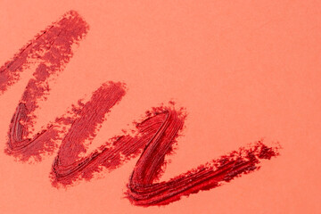 Brush strokes of paint on pink background, lipstick marks on paper