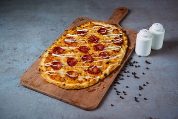 Pepperoni Pizza with black pepper serving on wooden cutting board isolated on grey background top view of fastfood