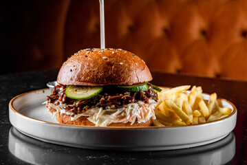 Traditional barbecue pulled beef burger with vegetables with french fries 