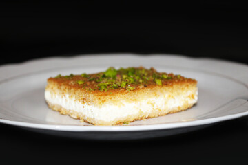 Hot tasty Knefe, Knafeh on white dish, Lebanese, Syrian, Turkish, Jordan, Palestinian  dessert.