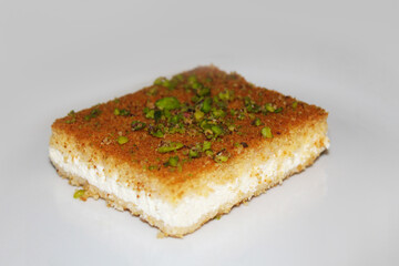 Hot tasty Knefe, Knafeh on white dish, Lebanese, Syrian, Turkish, Jordan, Palestinian  dessert.