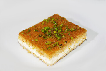 Hot tasty Knefe, Knafeh on white dish, Lebanese, Syrian, Turkish, Jordan, Palestinian  dessert.