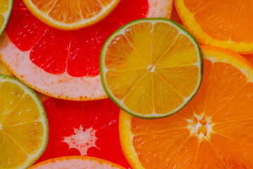 Naklejka na ściany i meble Top view: colorful fresh citrus fruits slices - lemon, orange, grapefruit and lime - close up. Tropical, natural, exotic, summer and healthy food concept