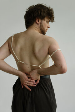 A cute guy's back with pearls on it and hands 