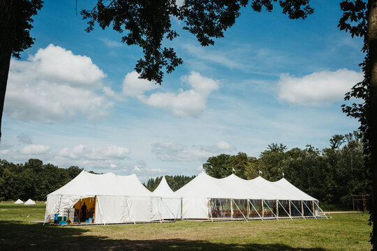 Wedding party tent on a field in between trees