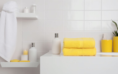 Fototapeta na wymiar Contemporary white bathroom with yellow details creating a sunny atmosphere.