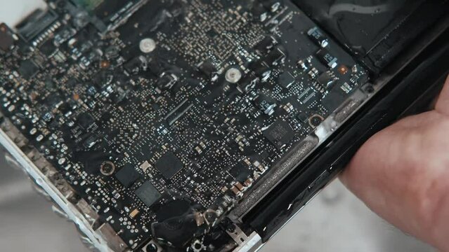 Close up video of washing under water motherboard on laptop.