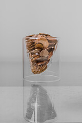 A pile of coins in a glass in the shape of a skull. Money that kills. Coins in the shape of a skull. Disliked job. Credit pit. Dirty money. Death by money.