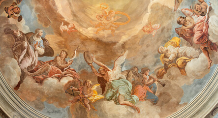 DOMODOSSOLA, ITALY - JULY 19, 2022: The fresco in baroque cupola - angels with the music instruments and the siants in the church Chiesa dei Santi Gervasio e Protasio by Lorenzo Peretti (1774 – 1851).