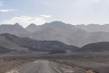 Panoramic view of endless empty road leading to colorful geology of multi hued Artist Palette rock...