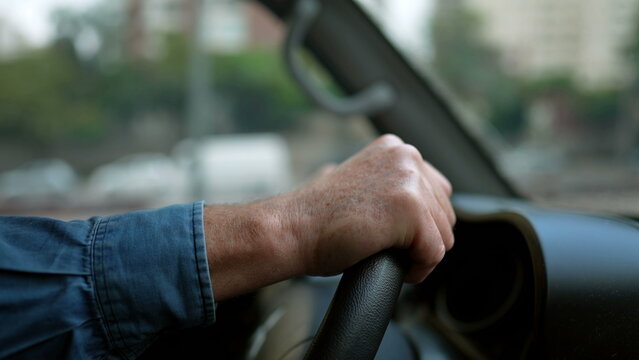 Closeup of person hands on steering wheel driving car. Man driving a vehicle. Slow motion 120fps driving commuting from work
