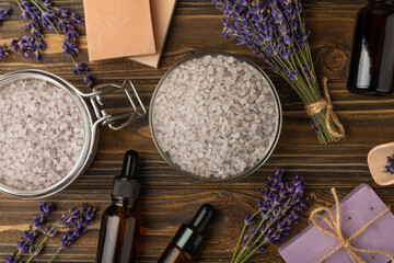 Fototapeta na wymiar Lavender spa. Essential oils, sea salt, handmade soap, cream and body scrub with lavender flowers on brown texture wood. Natural herbal cosmetics with flowers and lavender aroma.Aromatherapy and relax