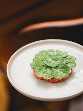 Steak Tartare topped with glazed nasturtium leaves. 