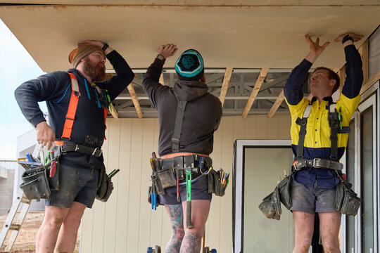 Three tradies work as a team