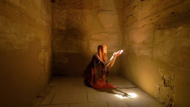 2022 - A kneeling interpretive dancer performance through a shaft of sunlight in the Karnak Temple Complex.