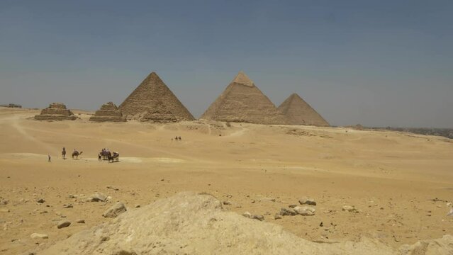 2022 - Excellent ascending view of the pyramids of Giza from behind a rock.