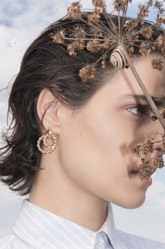 Beauty portrait of a model wearing gold earing in nature