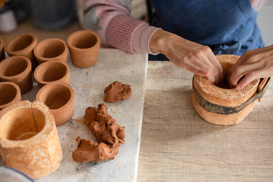 woman stuffing clay into a mold