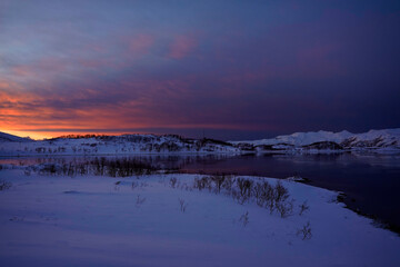 landscape sunset in snowy nature and sea in tromso