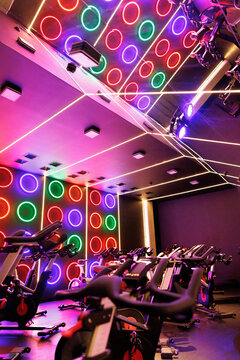 Exercise machine. Neon illumination. Fitness equipment. Gym interior