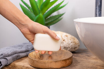 hand holding soap near sink with water