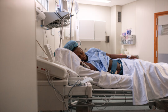 Pregnant female lying on side on hospital bed